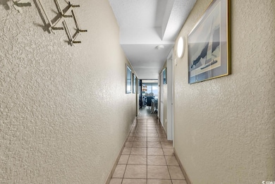 Corridor featuring a textured ceiling and light ti