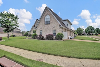 View of home's exterior featuring brick siding, a garage, a lawn, and driveway