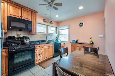 Kitchen featuring black appliances, tasteful backsplash, light tile patterned floors, brown cabinetry, and recessed lighting