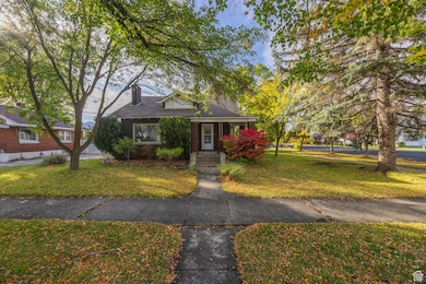 Bungalow featuring a front lawn, a chimney.