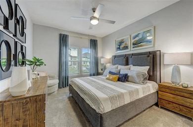 Bedroom featuring ceiling fan and carpet