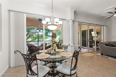 Dining room with a ceiling fan, a chandelier, crown molding, and ornate columns