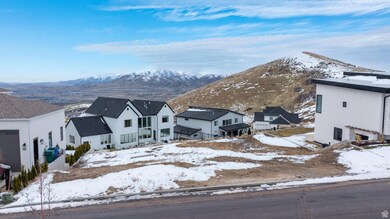 Snowy aerial view featuring a mountain view and a residential view