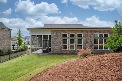 Back of property with a sunroom and brick siding