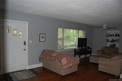 Large living room with wood flooring, bookcase, ce