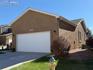 View of side of property with stucco siding, concrete driveway, and an attached garage