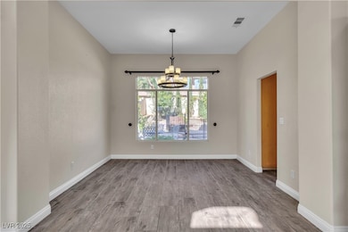 Unfurnished room featuring a chandelier, wood fini