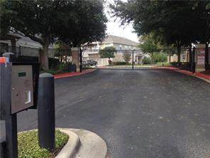 View of street with a gate, a gated entry, and cu