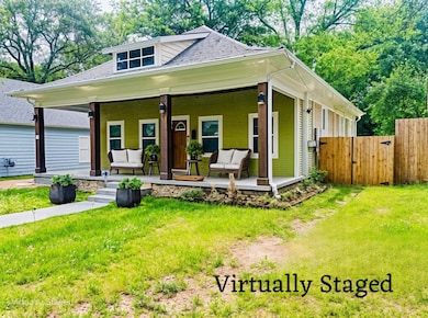 View of front of home featuring a gate, roof with 