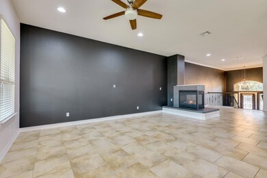 Unfurnished living room featuring ceiling fan wit