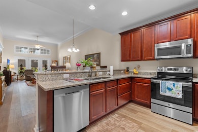 Kitchen featuring a sink, open floor plan, a penin