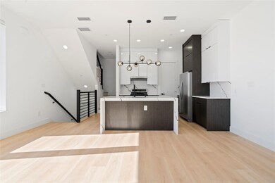 Kitchen with white cabinets, light countertops, hanging light fixtures, and modern cabinets