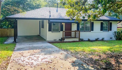 Ranch-style home featuring brick siding, an attached carport, crawl space, roof with shingles, and concrete driveway