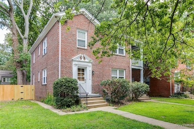 View of front of house with brick siding and a gat