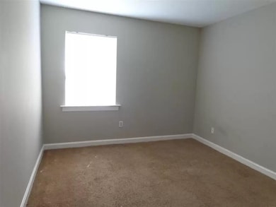 Carpeted empty room featuring baseboards