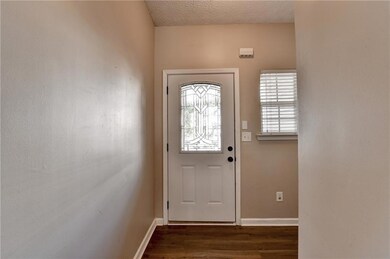 Doorway to outside with dark wood-style floors and baseboards
