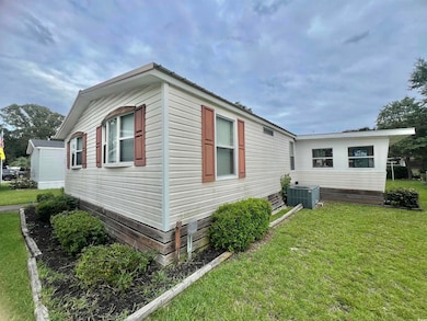 View of home's exterior with a yard and a cooling unit