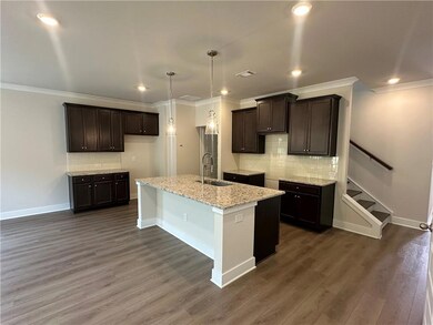 Kitchen featuring a sink, dark brown cabinets, tasteful backsplash, baseboards, and ornamental molding