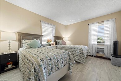 Bedroom with cooling unit and a textured ceiling