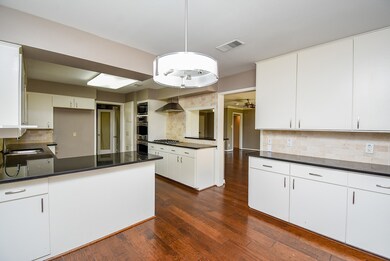 The spacious kitchen features granite countertops,