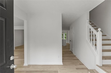 Entryway with light wood-style flooring and stairway