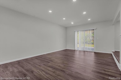Empty room featuring recessed lighting and dark wood-type flooring