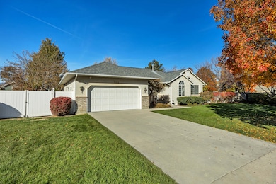 Ranch-style home with concrete driveway, a garage, a gate, roof with shingles, and brick siding