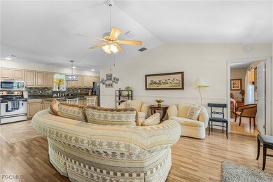 Living area featuring a ceiling fan, vaulted ceiling, light wood finished floors