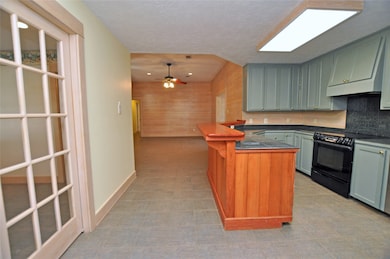 This photo showcases a spacious kitchen with light