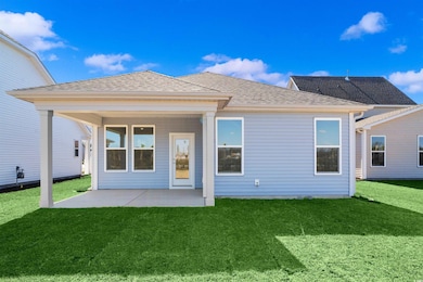 Back of house featuring a lawn, roof with shingles, and a patio