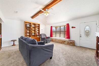 Carpeted living room featuring ceiling fan, lofted