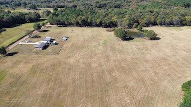 Aerial view of sparsely populated area featuring a nearby body of water and a heavily wooded area