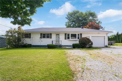 Ranch-style home with a garage and a front lawn