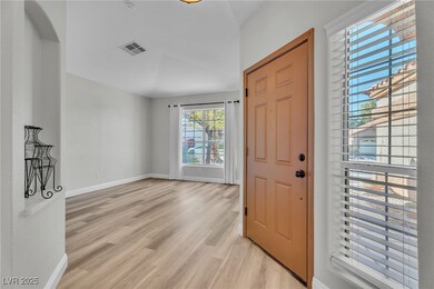 The living room has a nice large window, vaulted ceilings tucked right off the front door.