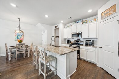 Kitchen featuring white cabinets, sink, hanging li