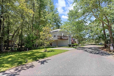 View of front of house with a front lawn, driveway, and a balcony