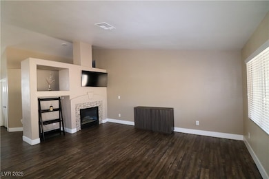 Family room with dark wood-style floors, a firepla