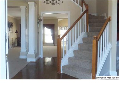 FRONT DOOR VIEW OF THE FOYER, WINDING STAIRCASE, A