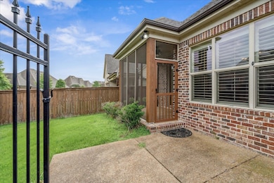 Doorway to property featuring brick siding and a patio area
