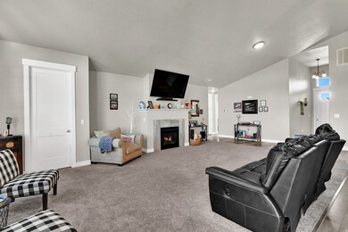 Carpeted living area featuring vaulted ceiling and a premium fireplace