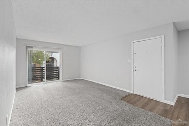 Empty room with a textured ceiling, baseboards, and wood finished floors