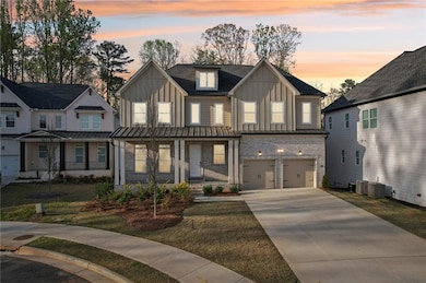 View of front of house featuring board and batten siding, concrete driveway, a garage, and a porch