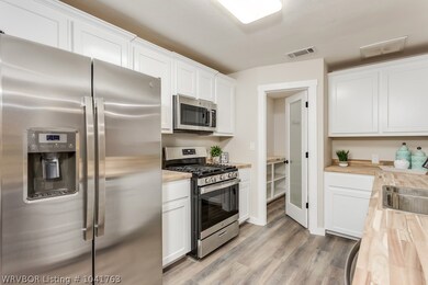 This open kitchen features all new stainless steel appliances with warranties as well as a HUGE walk in pantry with butcher block shelves.