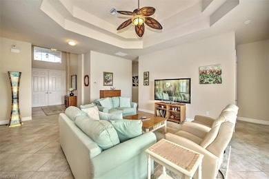 Tiled living room with ceiling fan, a towering cei