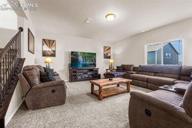 Carpeted living area featuring stairway and baseboards