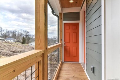 Covered front porch with tongue and groove panelled ceiling and door to 1 of 2 outside walk in storage rooms