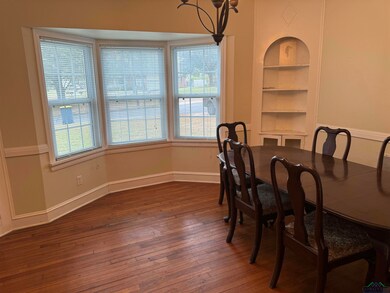 Dining room with dark wood-type flooring and built