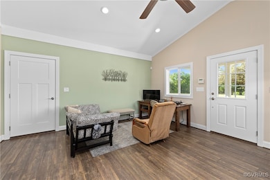 Living room featuring a ceiling fan, vaulted ceili