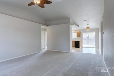 Unfurnished living room with light colored carpet, lofted ceiling, and a ceiling fan