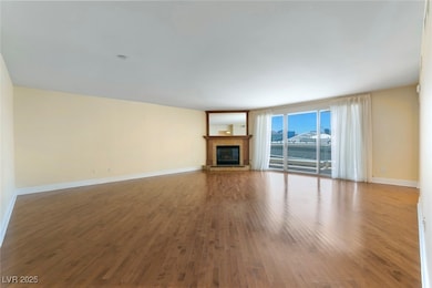 Unfurnished living room featuring wood finished fl